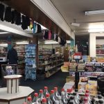 Inside a petrol station shop with various items on sale and an empty display stand.
