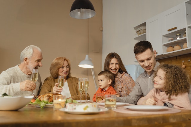 three generations sharing a meal at a table
