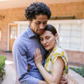 sad couple outside in front of house