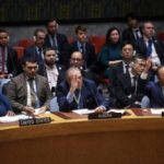 Meeting of the UN Security Council with Russian and Chinese delegates raising hands to veto ceasefire