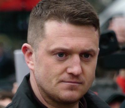 Closely cropped photo.of a while man with short dark hair