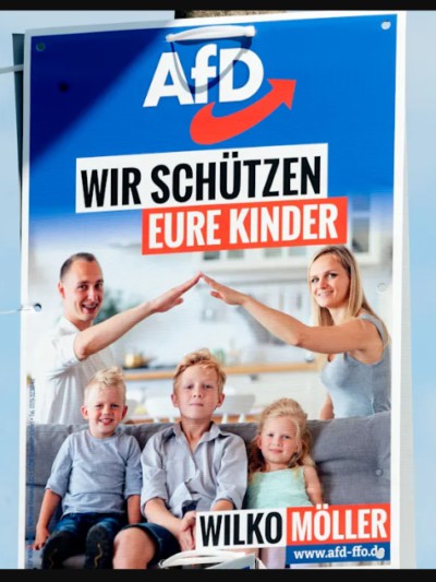 Promotion poster for the German AfD party. Three white children with blonde hair sitting on a blue sofa Blonde mother and father behind them doing Nazi salutes with their fingers touching to form an apex over the children.