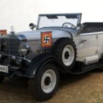 Silver grey German military car with swastika side pendants.