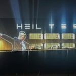 Image of Elon Musk doing a Nazi salute projected on to the front of a Tesla factory