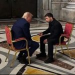 Donald Trump and Volodymyr Zelensky seated alone in conversation. Zelensky is gesturing towards Trump.
