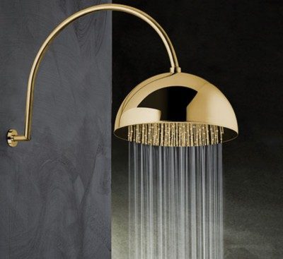 A shower head finished in gold with water streaming out