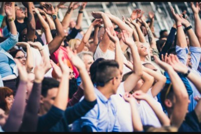 Crowd in a stadium with their arms raised