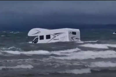 A white camper van half submerged in the sea
