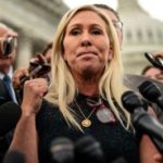 Blonde woman with no brains in front of lots of microphones.