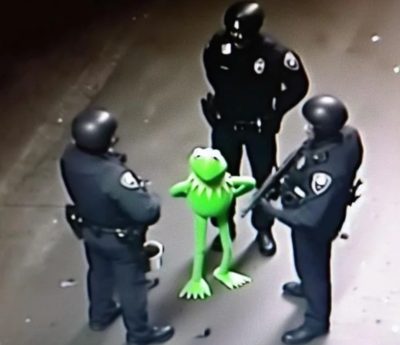 Kermit the frog handcuffed and surrounded by three armed police officers. Possibly AI generated