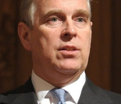 Prince Andrew wearing a grey jacket, white shirt and light blue tie.