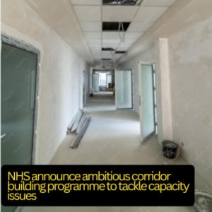 A long corridor with plastered walls and a few ceiling panels missing. Various building materials and buckets on the floor. Text - NHS announce ambitious corridor building programme to tackle capacity issues.