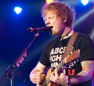 Ed Sheeran on stage playing guitar and singing